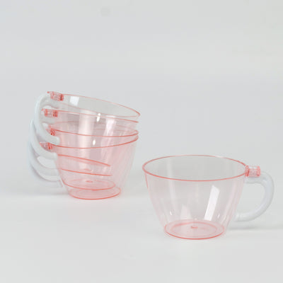 Stack of four transparent pink measuring cups on white background