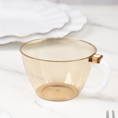 Amber plastic cup with a white handle on a marble surface.
