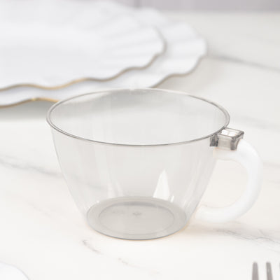 Clear plastic cup with handle on a marble surface.