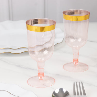 Elegant pink plastic goblets with gold rim, perfect for stylish dining.
