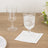 Two elegant drinking glasses on a wooden table with a napkin.