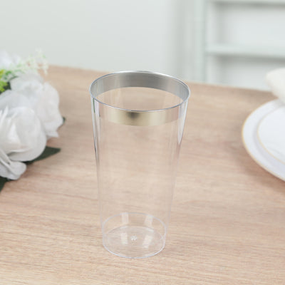 Clear plastic tumbler with metallic rim on wooden table.