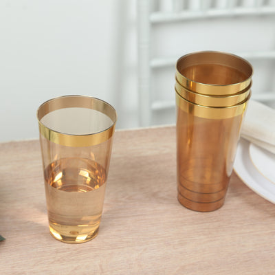 Gold-trimmed transparent cups on a wooden table.