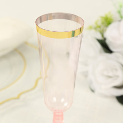 Pink champagne flute with gold rim on a soft background.