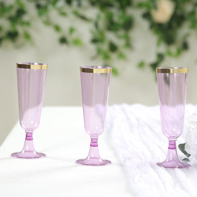 Set of three elegant pink champagne flutes with gold rims.