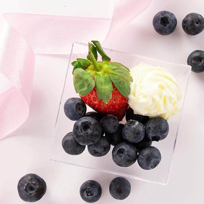 Strawberry and blueberry dessert in clear cup with whipped cream
