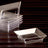Clear plastic jewelry display trays stacked on a dark wooden surface
