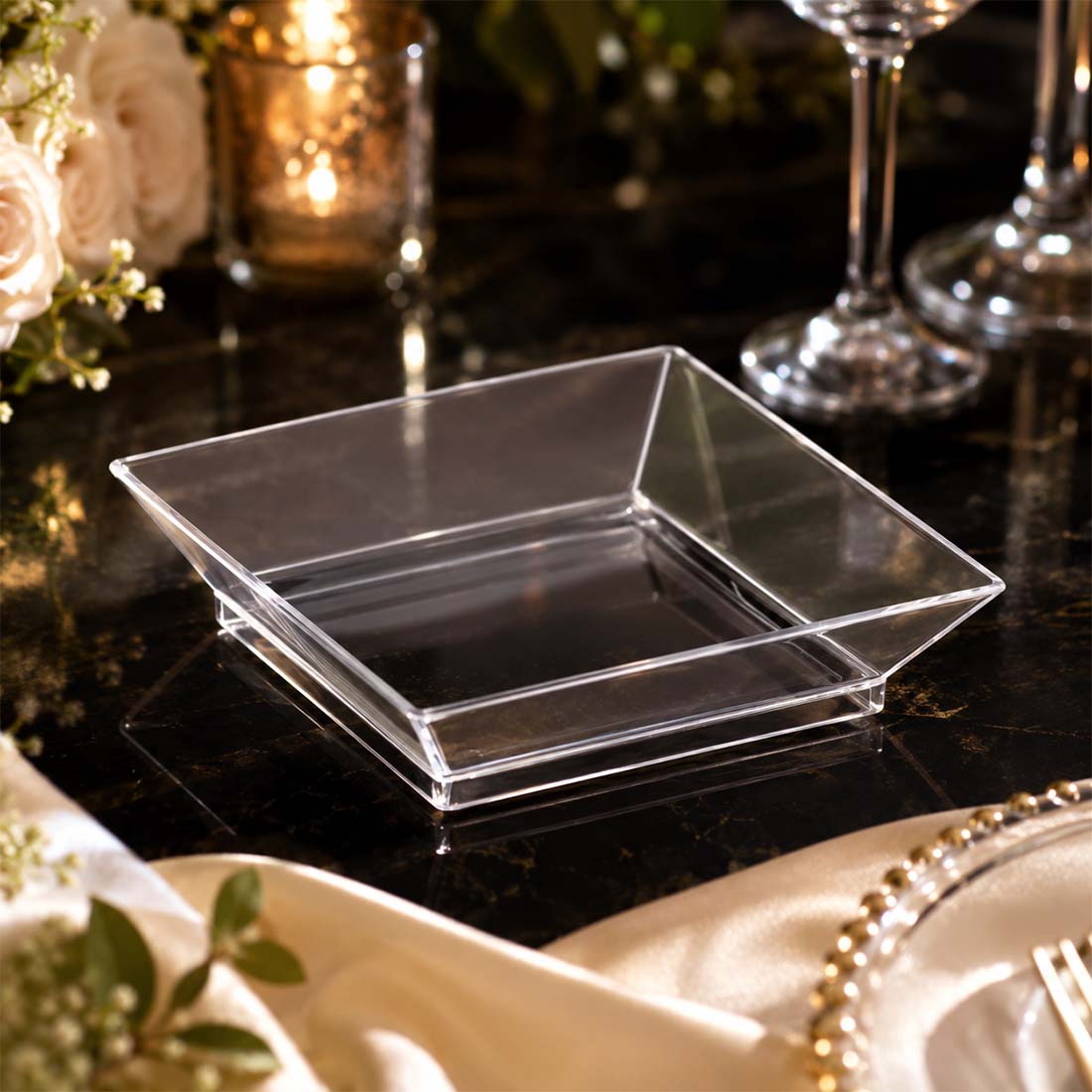 Clear acrylic square serving bowl on elegant black and gold table setting