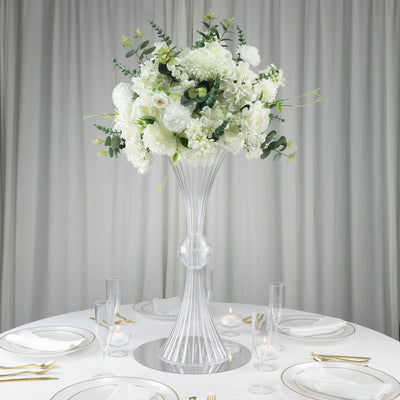Elegant floral centerpiece in a tall glass vase, perfect for weddings or events.