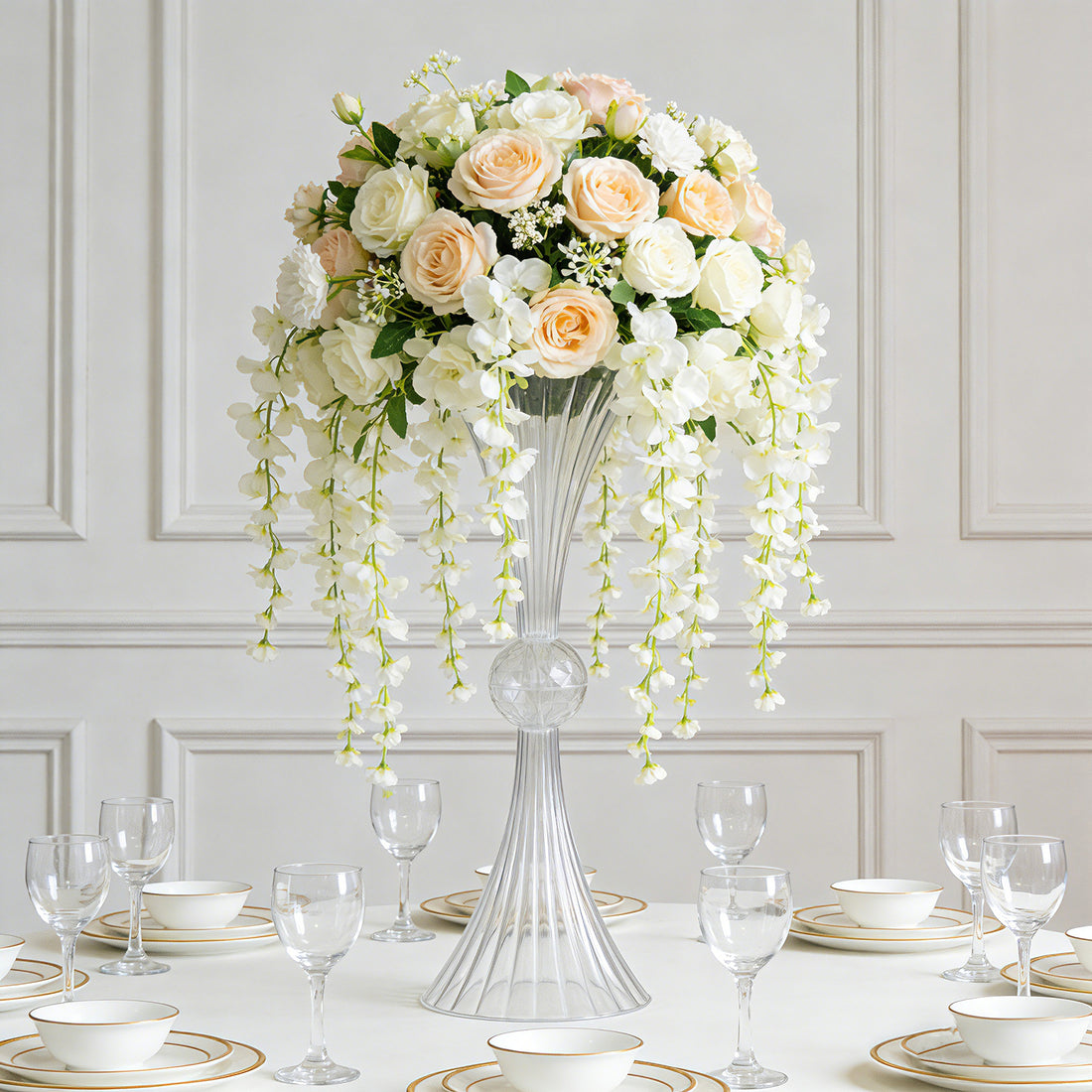 Elegant floral centerpiece with roses and orchids in a glass vase.