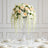 Elegant floral centerpiece with roses and orchids in a glass vase.