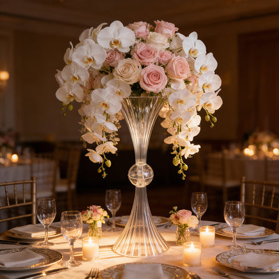 Elegant floral centerpiece with white orchids and pink roses in a crystal vase.