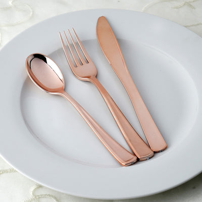 Rose gold cutlery set on a white plate.