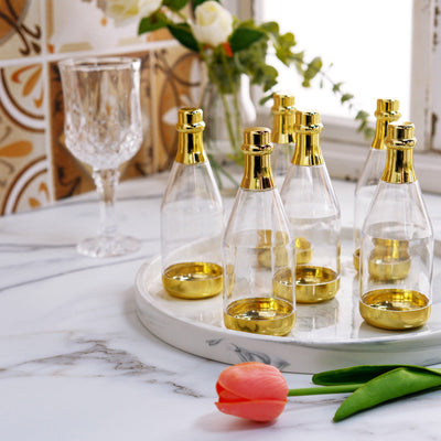 Elegant glass bottles with gold caps on a marble tray. Stylish home decor.