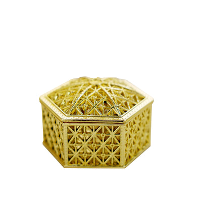 Gold decorative hexagonal box with intricate patterns.