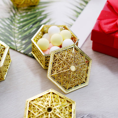Gold hexagonal decorative box with colorful balls inside.