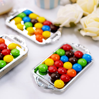 Colorful candy assortment in decorative trays on a light background.