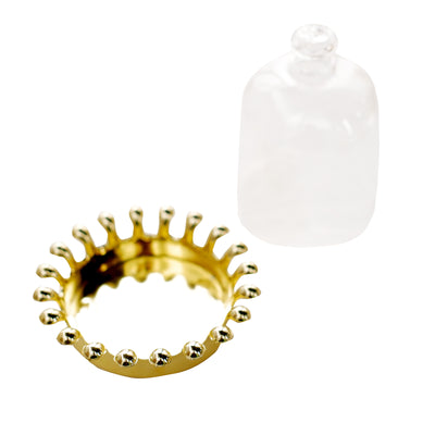 Gold crown ring and clear glass dome on a white background