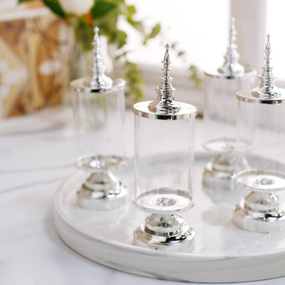 Set of elegant glass display jars with silver bases and decorative tops