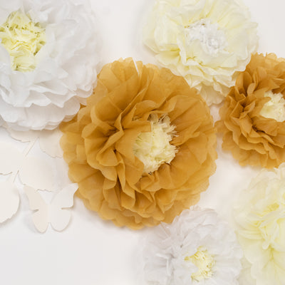 Tissue paper flowers in white, yellow, and gold on a white background