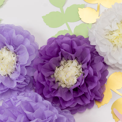Purple and white paper flowers on green and gold leaves