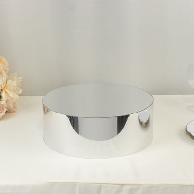 Round mirrored display stand on a neutral surface.