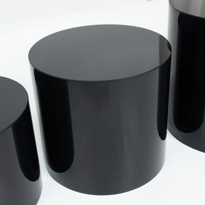 Glossy black cylindrical pedestals on white background