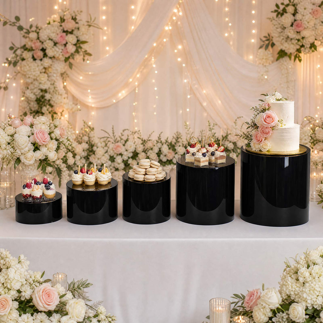 Elegant wedding dessert table with cakes, cupcakes, macarons, and floral decor