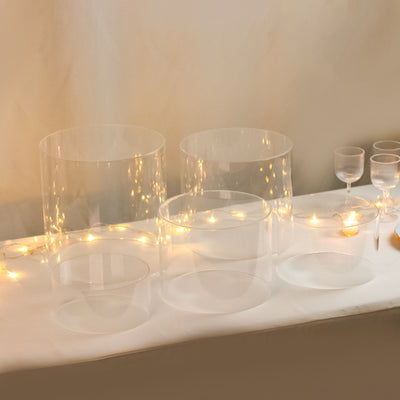Clear acrylic display cylinders in various sizes with soft lighting.