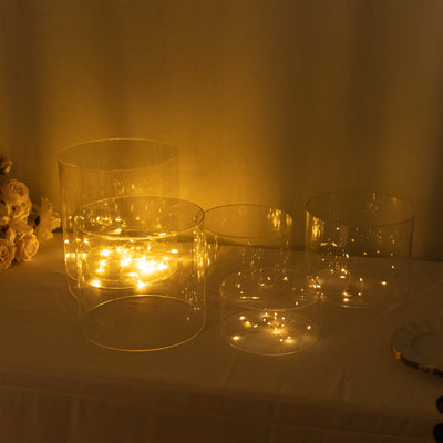 Decorative glass cylinders with warm fairy lights inside