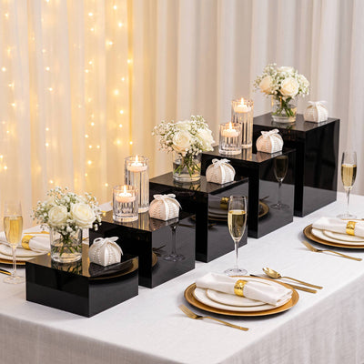Elegant black and gold wedding table setting with candles and white roses