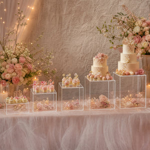 Elegant blush pink dessert table with floral cakes and cupcakes at a party display