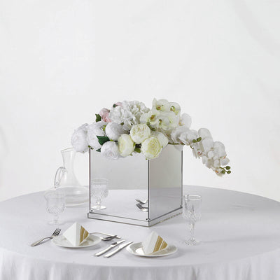 Mirrored floral arrangement centerpiece on a table setting with elegant tableware.