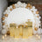 Elegant dessert display with gold accents and balloons backdrop.