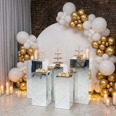 Elegant dessert display with mirrored stands and balloon decor for special events.