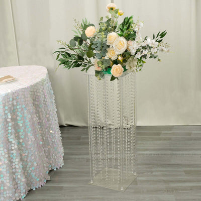 Clear flower vase with decorative beads and elegant floral arrangement.
