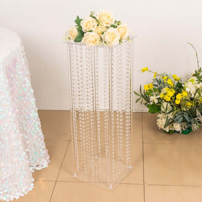 Clear acrylic flower stand with decorative beads and roses arrangement.