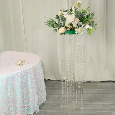 Acrylic flower stand with cascading beads and floral arrangement.