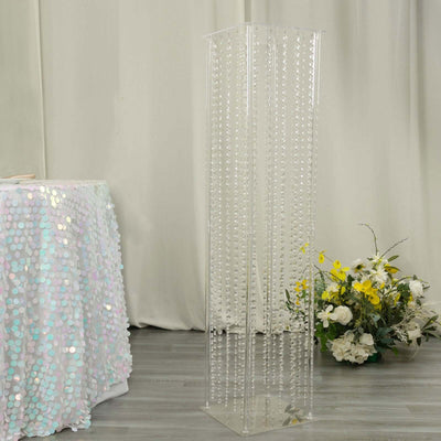 Clear acrylic column with hanging beads, perfect for event decor.