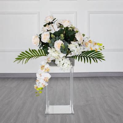 Elegant floral arrangement featuring roses, orchids, and greenery in a modern vase.