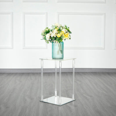Clear acrylic side table with a vase of flowers on top.