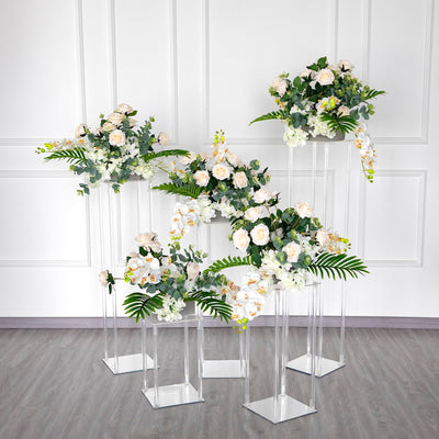 Elegant floral arrangements in clear stands against a white backdrop.