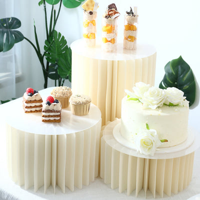 Elegant dessert display with cakes, cupcakes, and parfaits on cream stands
