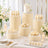 Elegant white floral dessert table with cake, cupcakes, macarons, and candles