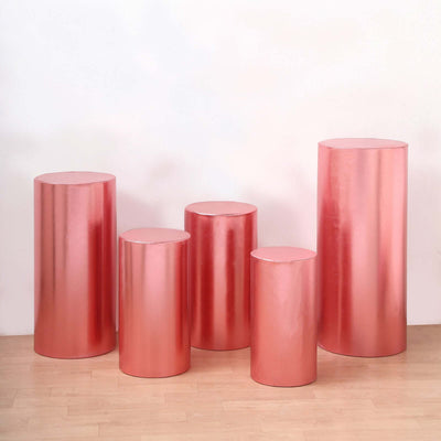 Set of five pink metallic display pedestals in varying heights