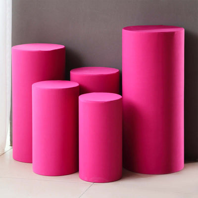 Colorful pink display pedestals of varying heights in a studio setting.