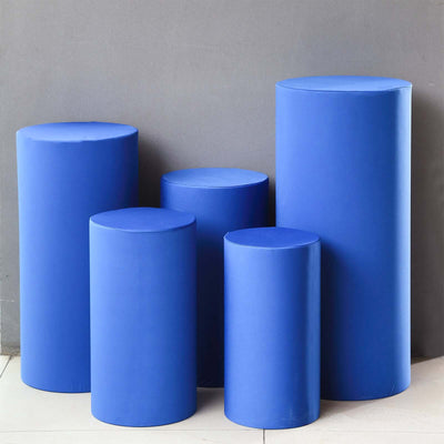 Blue cylindrical display pedestals in varying heights and sizes.