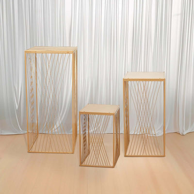 Set of three modern wooden side tables with geometric metal frames.