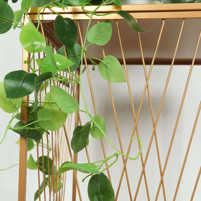 Gold geometric plant stand with artificial greenery