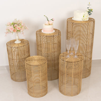 Rattan display stands with floral arrangements and cakes for events and decor.